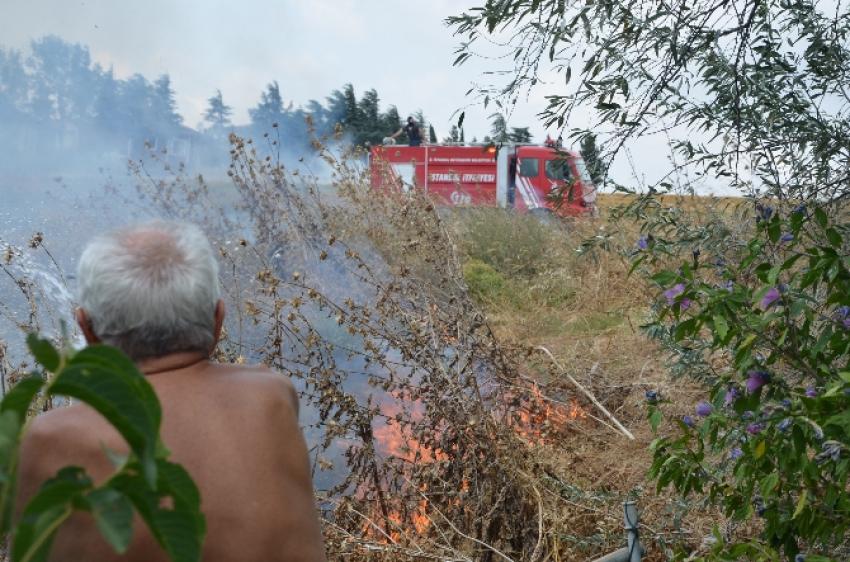 Evini korumak için alevlere hortumla müdahale etti