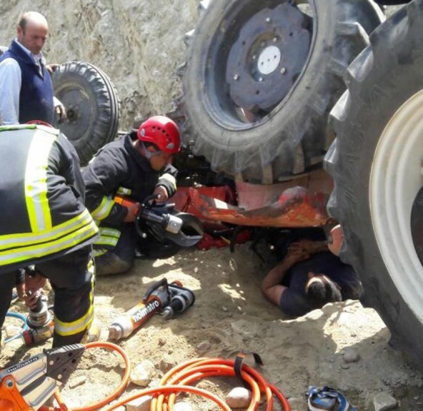 Devrilen traktörün altından güçlükle kurtarıldı