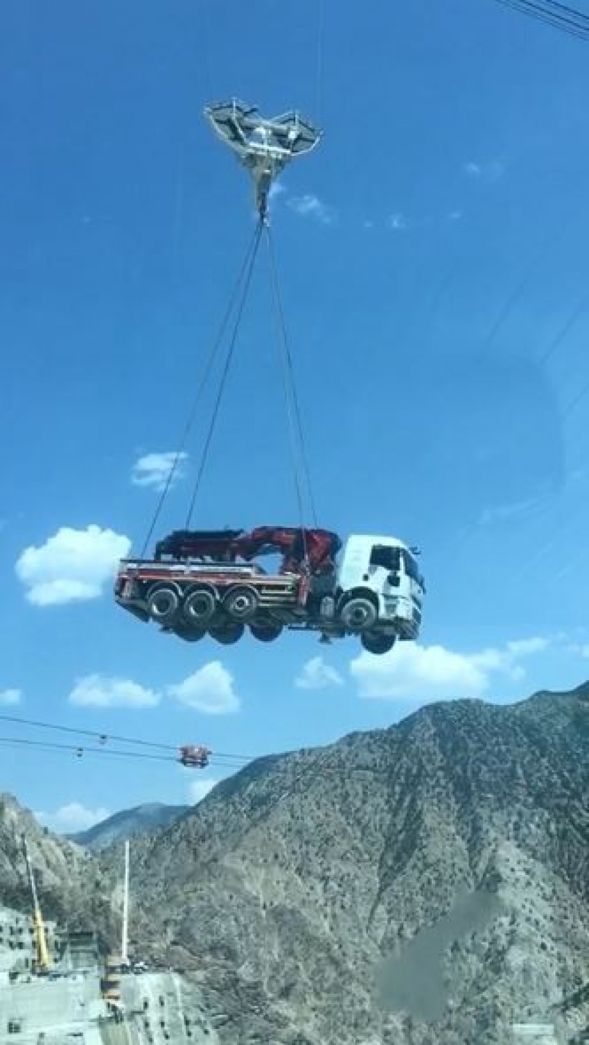 Tonlarca ağırlıktaki iş makineleri Yusufeli Barajı inşaatında bir yamaçtan bir yamaca böyle taşınıyor