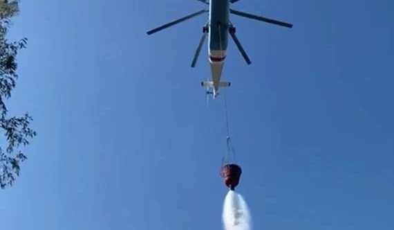 Helikopterin soğutma çalışmasını çeken muhabirler tonlarca suyun altında kalıyordu