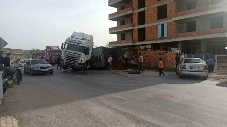 Kum boşaltan tır dorsesi yan yattı
