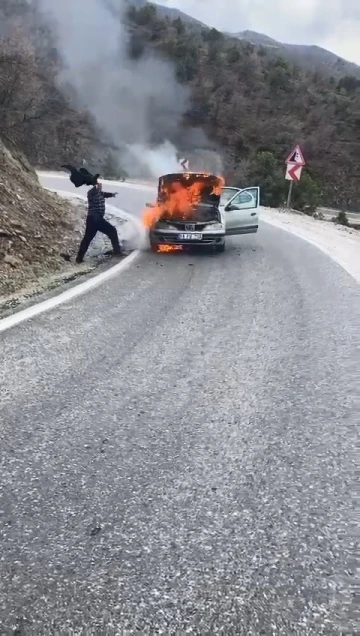 Alev alev yanan otomobili ceketi ile söndürmeye çalıştı, imdadına diğer sürücüler yetişti
