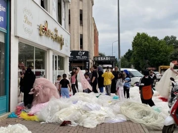 Bursa'da mağaza önüne koyduğu geçen sezonun kiralık gelinliklerini ücretsiz olarak dağıtıyor