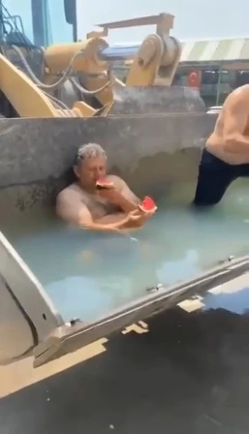 Sıcaktan bunalan işçiler, kepçeyi havuza çevirdi